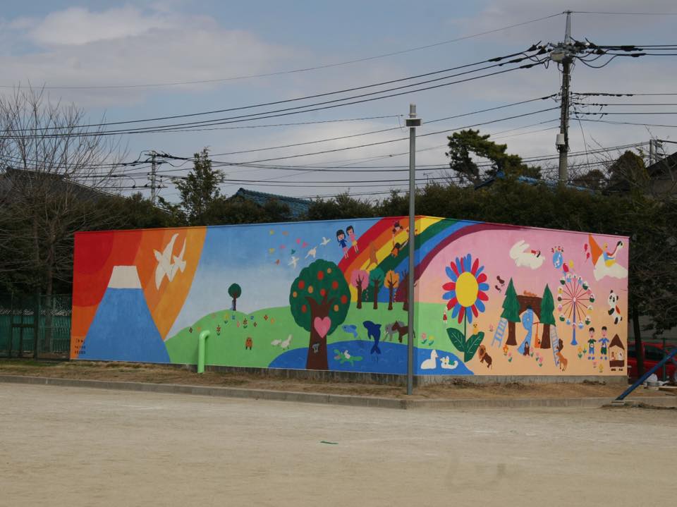 校庭の無機的な貯水槽の壁一面に子供たちの絵を再現 幸松小学校 有限会社ビッグアート